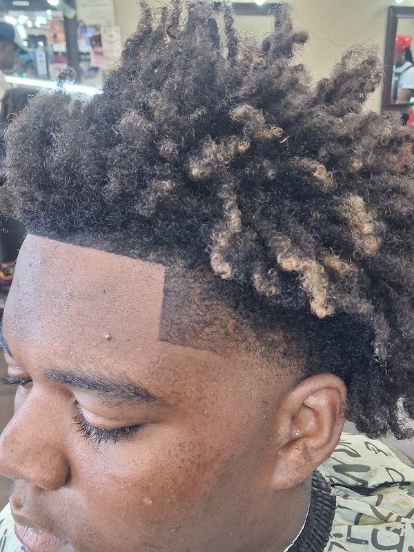 Twist-out with honey-blonde coloured tips over a blended fade and sharp corner.